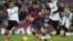 El delantero del FC Barcelona Lionel Messi con el balón ante los jugadores del Valencia