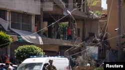 Agentes de policía y personal de emergencia trabajan en el lugar del ataque israelí en los suburbios del sur de Beirut, el 14 de junio de 2026. 
