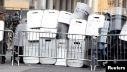 Policías antimotines en Honduras se cubren ante el avance de manifestantes que protestan por medidas del gobierno. Mayo 31 de 2019. (REUTERS).