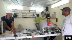 Un hombre arregla un celular en su negocio de reparación en La Habana.