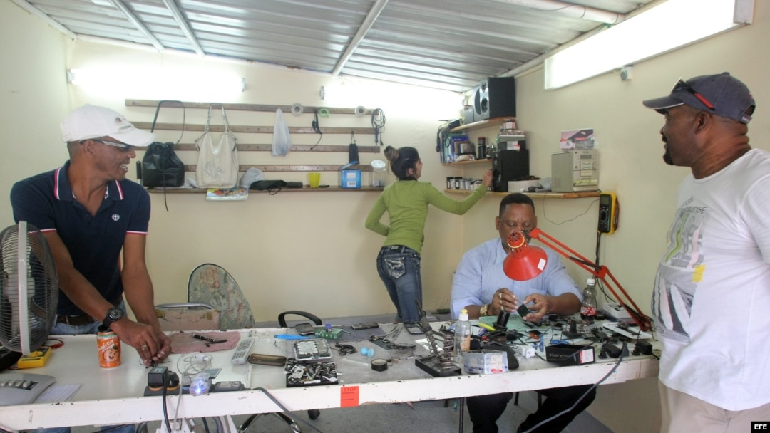Un hombre arregla un celular en su negocio de reparación hoy, viernes 19 de diciembre de 2014, en La Habana (Cuba). 