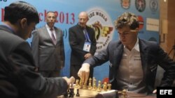 El campeón indio Viswanathan Anand (i) contesta el movimiento del aspirante al título mundial, el noruego Magnus Carlsen (d).
