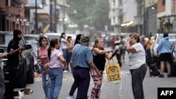 Personas permanecen en una calle tras un terremoto en Caracas