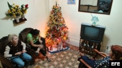 Archivo - Tres mujeres conversan en una casa decorada con un árbol de Navidad.