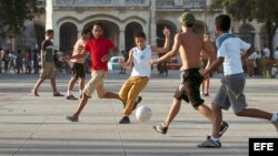 Varios estudiantes cubanos juegan fútbol en un parque en La Habana, Cuba.