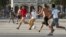 Varios estudiantes cubanos juegan fútbol en un parque en La Habana, Cuba.