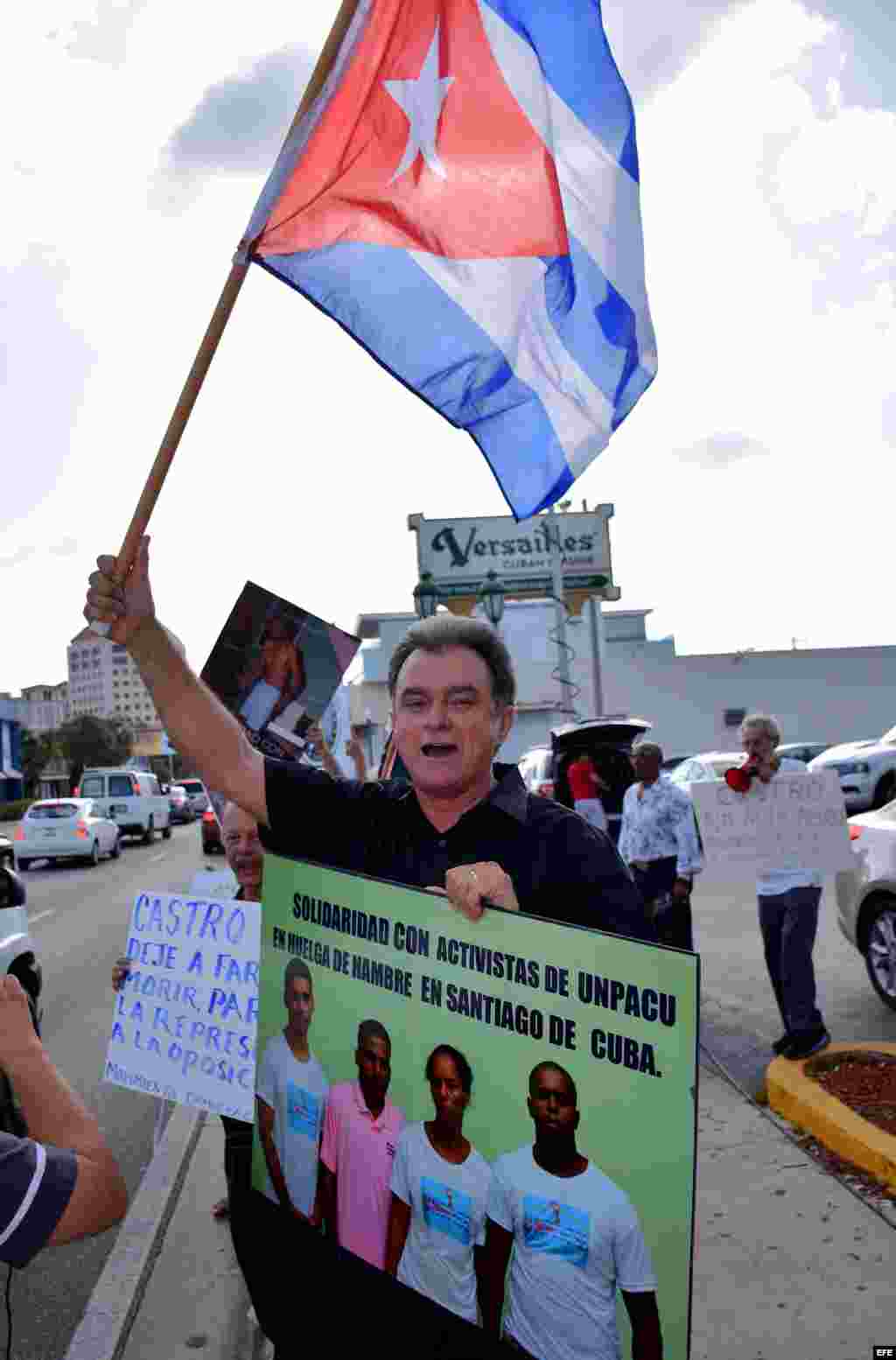 El presidente del Movimiento Democracia, Ramón Saúl Sanchez, sostiene una bandera cubana y un cartel con fotos de Fariñas durante una vigilia realizada hoy, miércoles 27 de julio 2016, frente al Restaurante Versailles en Miami