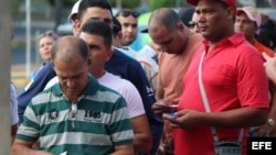  Decenas de cubanos hacen fila hoy, 10 de febrero de 2016, en la ciudad de David, capital de la provincia occidental panameña de Chiriquí, para comprar el boleto de avión, por 523,50 dólares cada uno, para viajar a México. Los 1.301 cubanos en tránsito ha