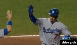 Alex Guerrero es recibido por otros Dodgers tras batear como emergente un jonrón que empató el juego.