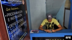Un cuentapropista técnico en reparación de celulares espera llegada de clientes en La Habana.