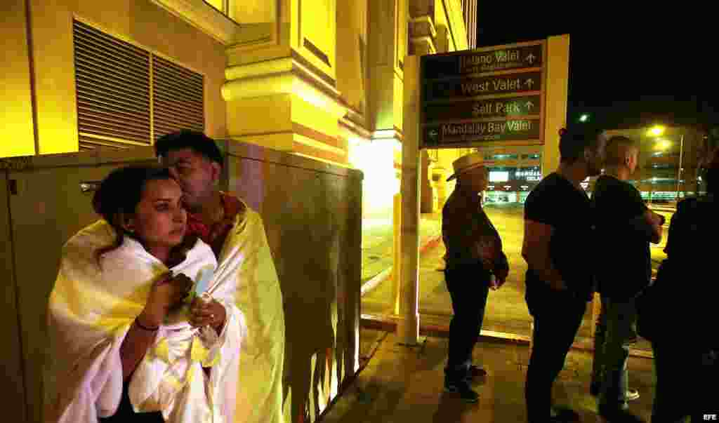 Varias personas permanecen a la entrada del hotel Mandalay Bay, cerca del lugar donde se produjo un tiroteo indiscriminado la pasada noche en Las Vegas.
