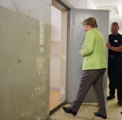 La canciller de Alemania, Angela Merkel, entra el 11 de agosto de 2017 a una celda del Memorial Berlin-Hohenschönhausen en lo que fueran los cuarteles de la STASI en el antiguo Berlín Oriental (Foto: Wolfgang Kumm/AFP).