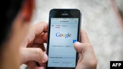 Una persona utiliza su celular para conectarse a Google en una zona Wi-Fi de Cuba.