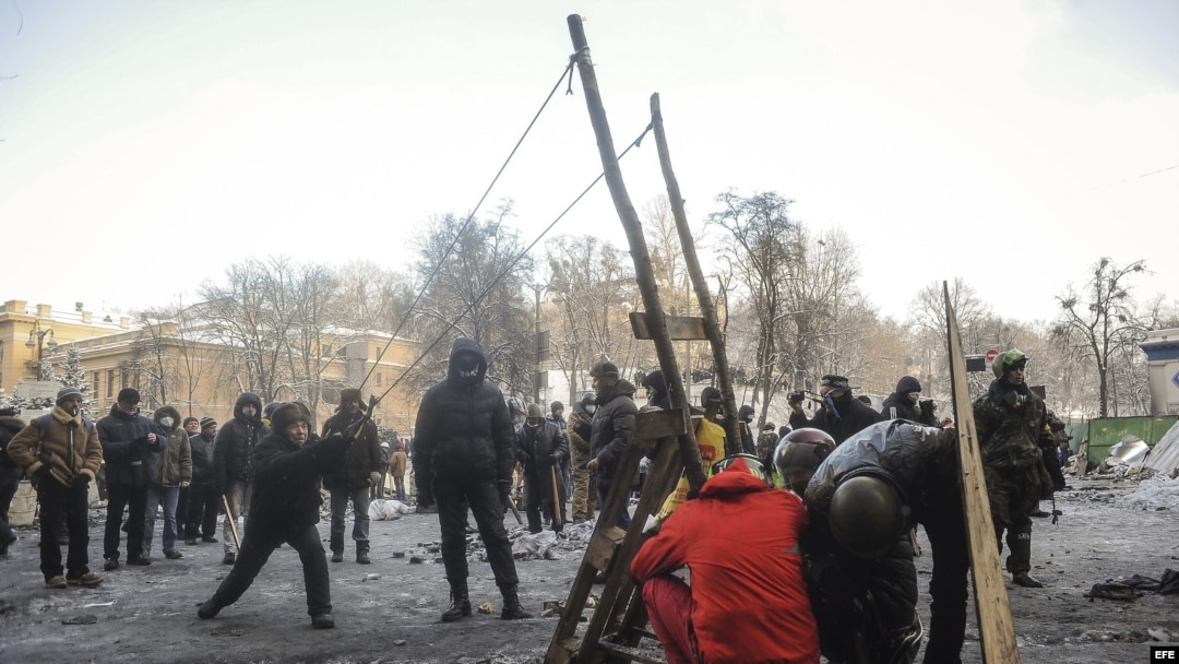 Un manifestante lanza un proyectil improvisado durante otra jornada de protestas en Kiev (Ucrania).