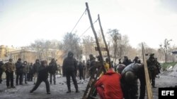 Un manifestante lanza un proyectil improvisado durante otra jornada de protestas en Kiev (Ucrania).