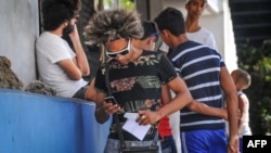 Un cubano usa su teléfono celular mientras camina por La Habana. Los SMS a teléfonos celulares en EEUU cuestan 0,60 CUC.