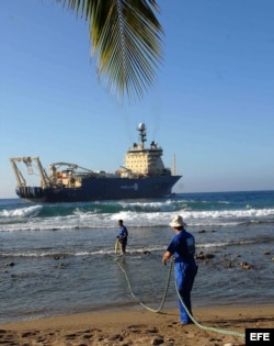 Obreros cubanos arrastran el cable submarino de fibra óptica en la playa de Siboney, en Santiago de Cuba.