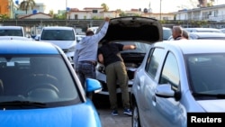 Potenciales compradores de autos inspeccionan un automóvil en La Habana, Cuba, el 25 de febrero del 2020.