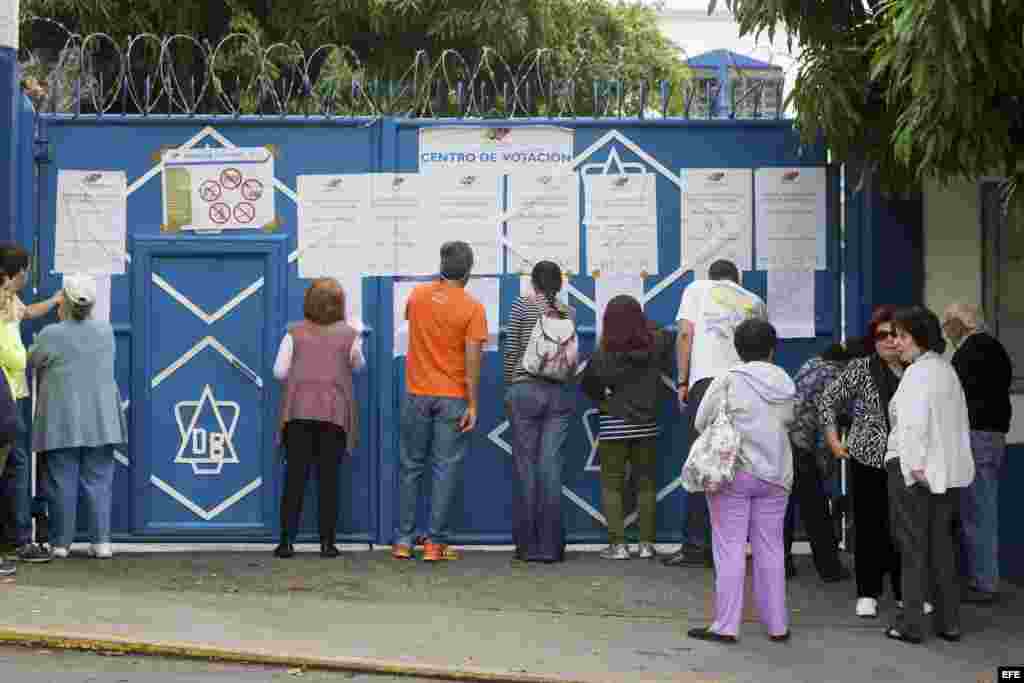 Un grupo de personas aguardan en la entrada de un colegio que sirve como centro de votación hoy 6 de diciembre del 2015 en la ciudad de Caracas.