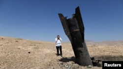 Parte de un misil sobresale del suelo, tras ataques de Irán en la zona central de Cisjordania, ocupada por Israel.