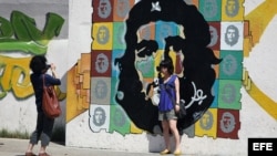  Turistas se toman fotos en un grafiti con la imagen del Ché Guevara 
