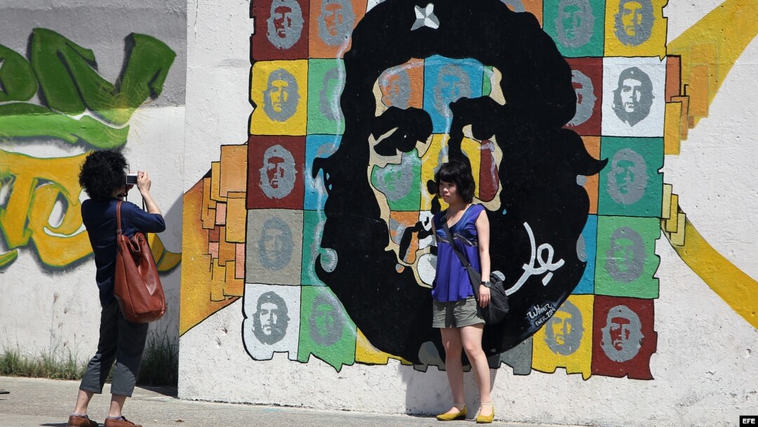  Turistas se toman fotos en un grafiti con la imagen del Ché Guevara 