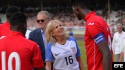 Jill Biden, y el Embajador de EEUU en Cuba, Jeffrey De Laurentis, saludan a los futbolistas cubanos en el estadio Pedro Marrero de La Habana.