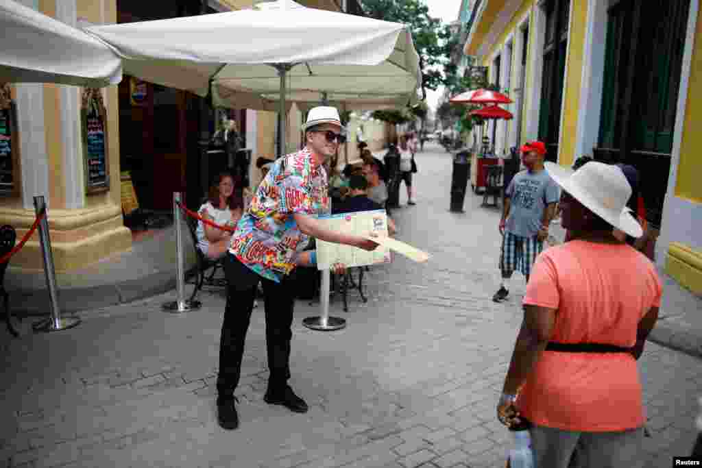 Eric Barreto, del restaurante La Vitrola, muestra el men&#250; a los turistas en La Habana. REUTERS/Fernando Medina