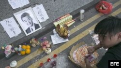 Un manifestante condena simbólicamente a Leung Chun Jefe Ejecutivo de Honk Kong, haciendo una ofrenda de comida, bebida y dinero, práctica tradicional china de recordar a los muertos. 