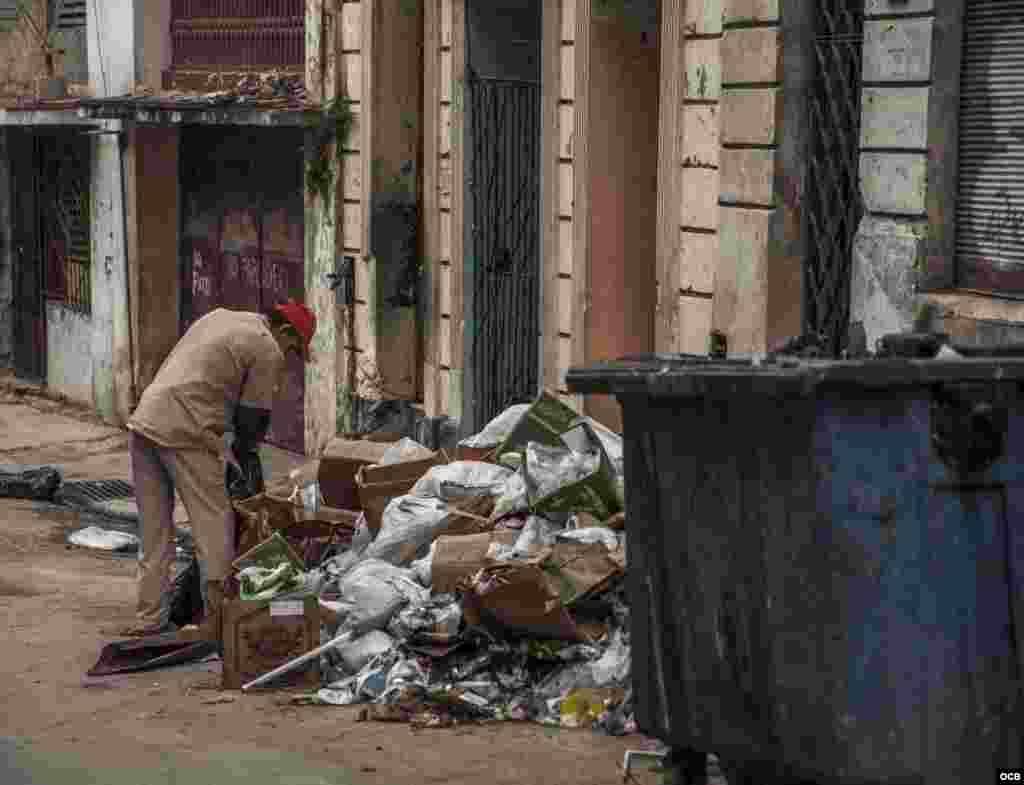 Anciano cubano buscando en la basura.
