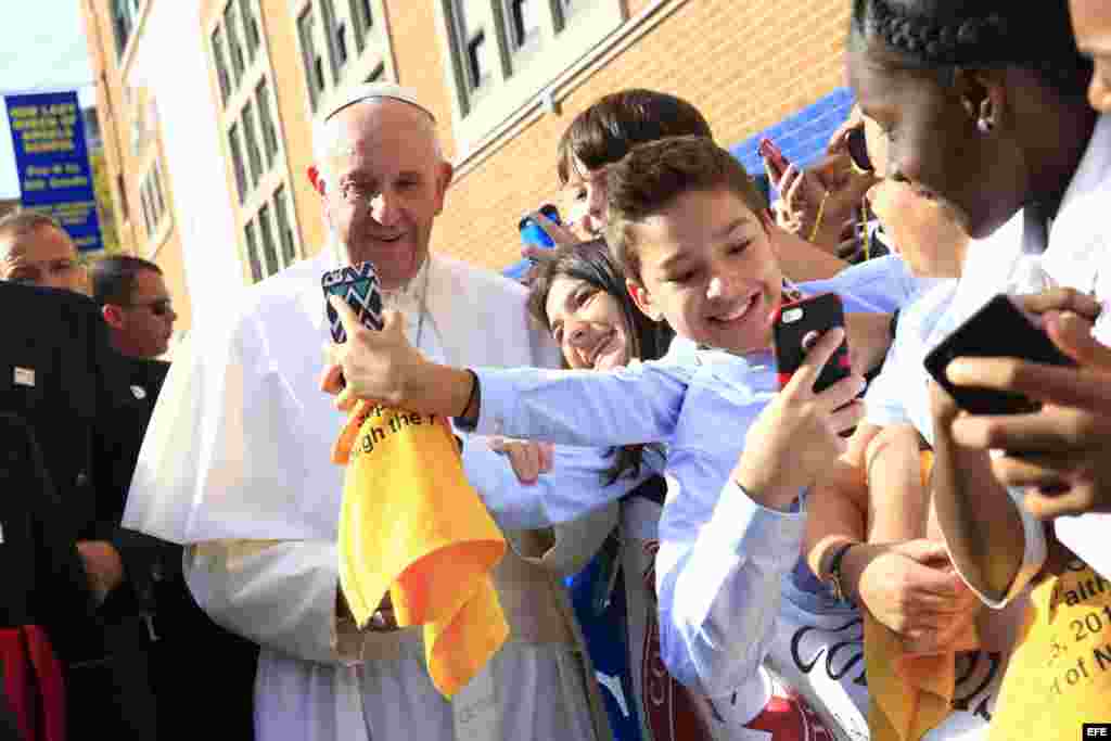 El Papa Francisco se toma selfies con los niños durante su visita a la escuela Nuestra Señora Reina de los Angeles. EFE