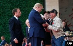 El presidente Trump saluda a uno de los veteranos del desembarco de Normandía.