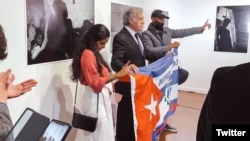 Anamely Ramos (izq.), el secretario general de la OEA Luis Almagro y El Funky levantan la bandera cubana con la inscripción "Patria y Vida". 