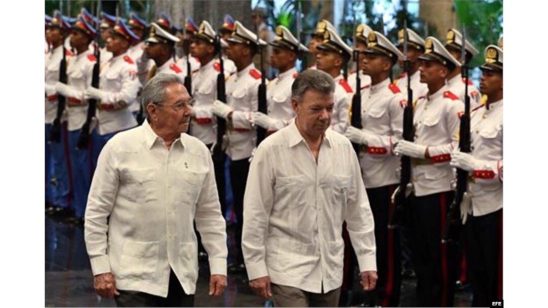 Raúl Castro (i) y el presidente de Colombia, Juan Manuel Santos (d), pasan revista a las tropas formadas para la ceremonia oficial de recibimiento 17 de julio de 2017.