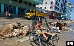 Una niña descansa fuera de su casa el11 de septiembre del 2017, después del paso del huracán Irma por La Habana (Cuba)