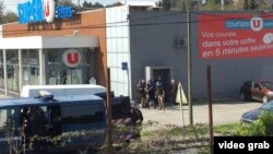 Policias franceses se emplazan a un costado del supermercado Super-U de Trebes, Aude, donde clientes y trabajadores fueron tomados como rehenes por un terrorista de origen marroquí.