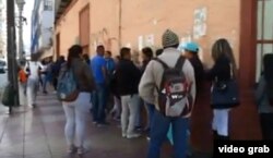 Migrantes hacen fila ante una oficina de Extranjería y Migración en Antofagasta, Chile.