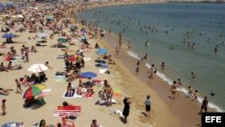 Fotografía de archivo de numerosos bañistas en la playa del Bogatell, Barcelona. 