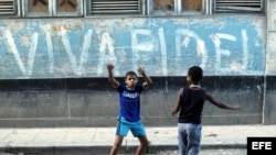 Dos niños juegan frente a una pintada alusiva al líder cubano Fidel Castro en una calle de La Habana.
