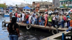 Cubanos abordando una embarcación en el muelle de Turbo.