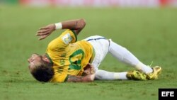 Neymar (c) es atendido por su compañero Marcelo (d) y el centrocampista colombiano James Rodríguez (i) tras recibir un golpe que le fracturó una vértebra. 