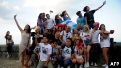 Jóvenes cubanos se toman selfies en el Malecón. YAMIL LAGE / AFP