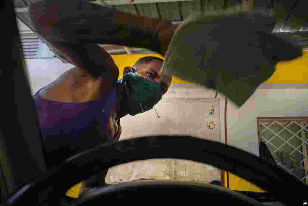 Un trabajador que usa una m&#225;scara como precauci&#243;n en medio de la propagaci&#243;n del coronavirus limpia un parabrisas en un lavado de autos en La Habana. (AP/Ram&#243;n Espinosa) 