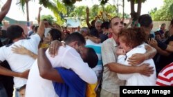 Fieles de la Iglesia "Fuego y Dinámica" en Camagüey se abrazan en el primer servicio después que las autoridades derribaran el cobertizo que habían levantado para practicar su religión.