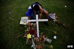 Un hombre deposita ofrendas en una cruz que simboliza las muertes en Nicaragua por las protestas.