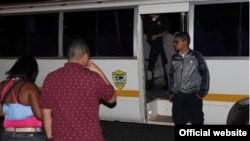 Dos migrantes ilegales son conducidos a un autobús del Servicio Nacional de Migración de Panamá.