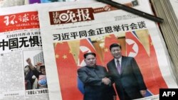 Portadas de diario chinos muestran imágenes de Xi Jinping y Kim Jong Un.