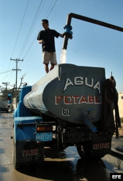 Water trucks, known as "pipas" or pipes in Cuba, are loaded with water to supply parts of Havana .