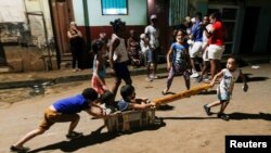 Un grupo de niños jugando en la calle sin protección contra el COVID-19.