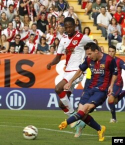 El delantero argentino del Barcelona Leo Messi (d) supera al defensa senegalés del Rayo Vallecano Abdoulaye Ba.